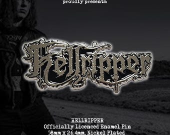May include: A nickel-plated enamel pin featuring the word "Hellripper" in a stylized font. The pin is officially licensed and measures 58mm x 26.4mm. The image also includes the text "783 MERCH proudly presents:" in a stylized font.