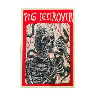 Puede incluir: Parche rectangular con borde rojo y las palabras "PIG DESTROYER" en blanco. El parche presenta una ilustración detallada de una figura esquelética con serpientes y ojos rojos, sobre un fondo texturizado.