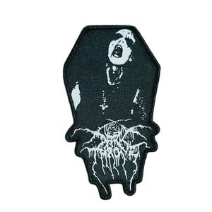 May include: Black and white embroidered patch in the shape of a coffin. The patch features a screaming figure and the word "TERRORIZER" in a stylized font. The patch is likely for clothing or accessories.