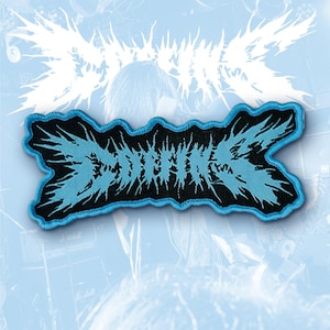 May include: A rectangular embroidered patch featuring a black background with light blue jagged, spiky lettering that reads "DOTHING". The patch has a thick, light blue stitched border that follows the irregular, sharp contours of the text design.