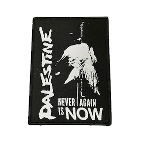Puede incluir: Parche rectangular negro con texto blanco y un gráfico de una persona. La palabra "PALESTINE" está alineada verticalmente a la izquierda. El texto "NEVER AGAIN IS NOW" está centrado en la parte inferior.