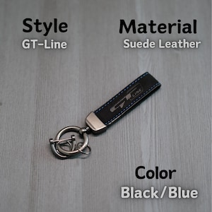 May include: Black and blue suede leather keyring with a silver metal ring and a GT-Line logo.