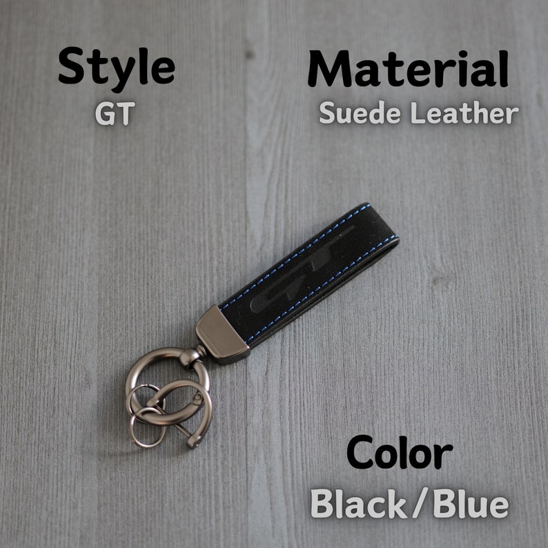 May include: Black and blue suede leather keyring with a silver key ring and the letters "GT" embossed on the leather.