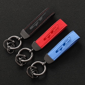 May include: Three keychains with leather straps and metal rings. The straps are black, red, and blue with the text "GT LINE" printed on each.