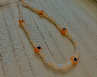 Orange evil eye phone charm