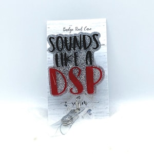 Könnte beinhalten: Ein silberner Glitzer-Badge-Rollenhalter mit einem roten und silbernen Glitzer-Anhänger, auf dem "Sounds Like a DSP" steht.