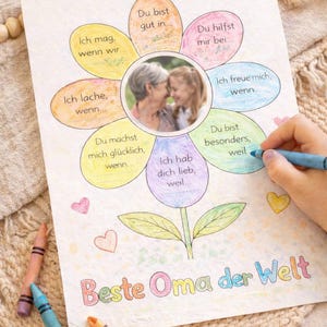 May include: A flower-shaped card with a photo of a grandmother and grandchild. The card has colourful petals with phrases like "I love you because..." and "You make me happy when..." The words "Best Grandma in the World" are written at the bottom.