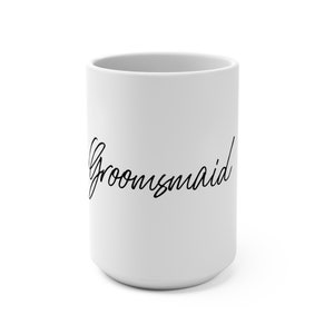 Może przedstawiać: Biały kubek ceramiczny z napisem "Groomsmaid" napisanym czarnym, ozdobnym pismem.