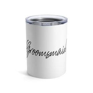 May include: White stainless steel tumbler with a black inscription that reads "Groommaid".