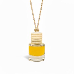 Small glass bottle with yellow liquid and wooden beads on a white background