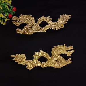 May include: Two gold-coloured dragon door handles. The dragons are intricately detailed and have a textured finish.
