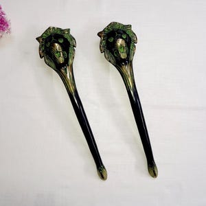 May include: Two black and green lion head door handles with a gold finish.