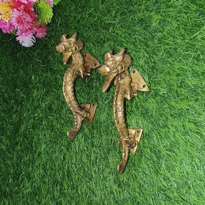 May include: Two gold dragon door handles with intricate details. The handles are made of solid brass and have a traditional Chinese design.