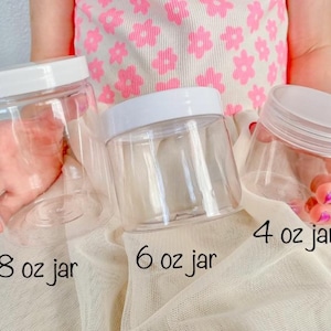 Pu&ograve; includere: Tre barattoli di plastica trasparente con coperchi bianchi, etichettati 8 oz, 6 oz e 4 oz. I barattoli sono vuoti e sembrano essere per conservare cosmetici o altri piccoli oggetti.