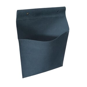 Può includere: Una tasca da parete blu scuro con un fronte curvo e un bordo superiore piegato. La tasca ha due piccoli fori vicino alla parte superiore. Il design è semplice e moderno, adatto per organizzare piccoli oggetti.