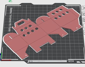 May include: A red cardboard box template with cut-out circles and a handle. The template is designed to be folded into a box.