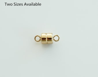 May include: Gold magnetic clasp for jewelry making. The clasp is made of two round pieces connected by a small metal bar. It is a simple and elegant way to finish a necklace or bracelet.