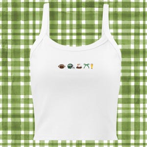 Op de afbeelding: Wit tanktop met een groene, witte en bruine voetbal, helm, adelaar, strik en bierglas afbeelding.