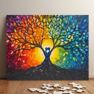 May include: A colorful painting of a tree with two figures embracing at the base. The tree has leaves in shades of red, orange, yellow, green, and blue. The figures are silhouetted against a bright yellow background.