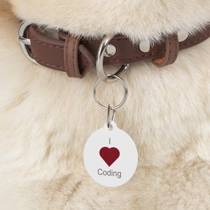 May include: White dog tag with a red heart and the text "I love Coding" on a brown leather dog collar.