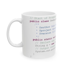 Puede incluir: Taza de cerámica blanca con un diseño impreso de código Java. El código incluye comentarios y una declaración de clase. El texto en la taza dice "// Start of Program public class Geeksi".