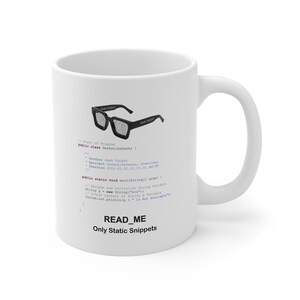 May include: White ceramic mug with a black graphic of eyeglasses and code snippets. The mug has the text "READ_ME Only Static Snippets" at the bottom. The mug has a curved handle.