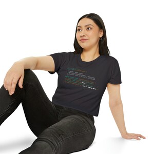 Może przedstawiać: Czarny, krótki t-shirt z nadrukowanym fragmentem kodu na przodzie. Fragment kodu zawiera tekst "Mia" i "Is in Debug Mode".