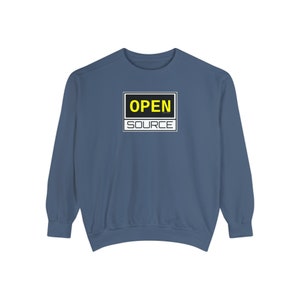 Puede incluir: Una sudadera azul oscuro con un letrero en blanco y negro que dice "OPEN SOURCE" en letras amarillas.