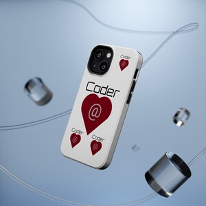 以下が含まれることがあります： 白い携帯電話ケースに赤いハートと「Coder」という文字が印刷されています。ハートの中に「at」の記号があります。ケースには3つのハートがあります。