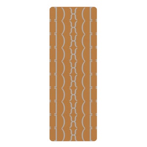 May include: A rectangular yoga mat with rounded corners. The mat features a repeating pattern of vertical, light gray lines and stylized shapes against a warm, orange-brown background. The design is symmetrical and modern.