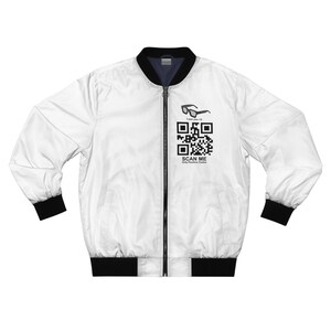 Puede incluir: Chaqueta bomber blanca con cremallera negra y puños de canalé negros. La chaqueta tiene un código QR en blanco y negro con el texto "SCAN ME" y "Only Positive Vibes" impreso en la parte delantera. Encima del código QR hay unas gafas de sol negras con el texto "I love you <3".