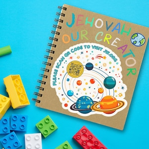 May include: A brown notebook with a spiral binding. The notebook has a white sticker with a colorful solar system design and the text "Jehovah Our Creator" and "Please Scan QR Code to Visit JW.ORG".