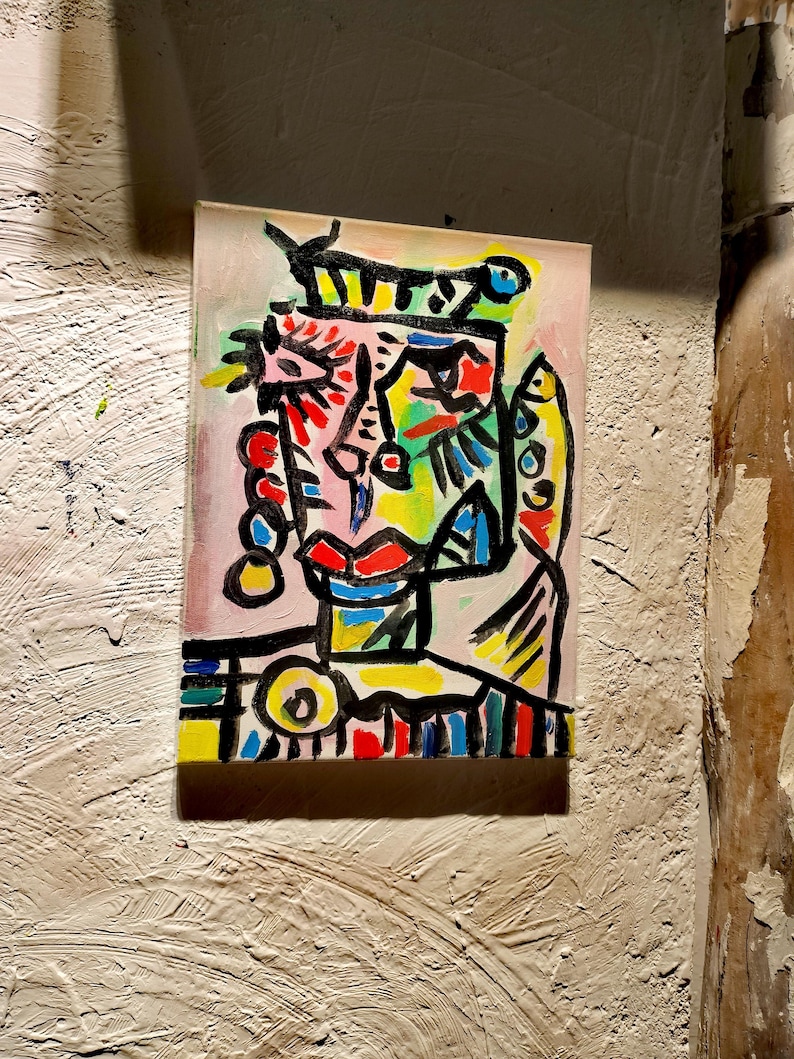 Puede incluir: Pintura abstracta de una cara con l&iacute;neas negras audaces y colores brillantes, incluyendo rojo, amarillo, azul, verde y rosa. La cara est&aacute; rodeada de un fondo blanco.