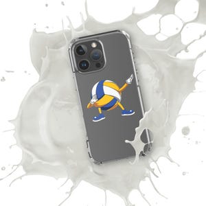 Op de afbeelding: Transparante telefoonhoes met een cartoon volleybalpersonage dat aan het dabben is. De volleybal is geel, blauw en wit, met blauwe schoenen. De telefoonhoes staat op een witte achtergrond met een spatteffect.