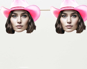 May include: A white background with a string of pink cowboy hats with female faces on them. Below the hats is a garland of green leaves, white and silver ornaments, and white lights.