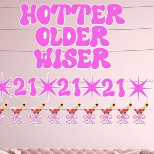 Könnte beinhalten: Rosa Wanddekoration mit den Worten "Hotter Older Wiser" in einer Blasen-Schriftart. Darunter die Zahlen "21" mit Sternen und Illustrationen von Cocktails mit Kirschen und Zitronenscheiben. Das Thema ist eine Geburtstagsfeier.