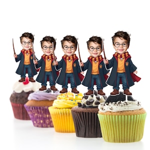 Könnte beinhalten: Sechs Cupcakes, die mit Harry-Potter-Toppern verziert sind. Jeder Topper zeigt eine Comicfigur, die eine schwarze Robe, einen rot-goldenen Schal trägt und einen Zauberstab hält. Die Cupcakes sind in verschiedenen Farben glasiert und haben Streusel.