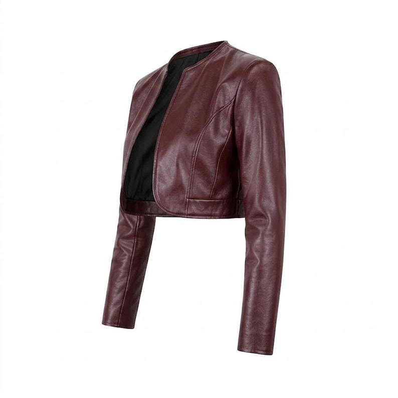 Three-quarter side angle of the burgundy leather collarless cropped jacket against a white background.