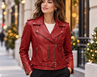 May include: A vibrant red leather motorcycle jacket featuring an asymmetrical front zipper, notched lapels with silver-tone metal snaps, three zippered pockets on the front, zippered sleeve cuffs, and an adjustable buckled belt at the waist.