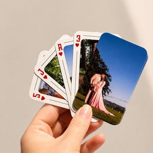 Hand holding personalised photo playing cards featuring wedding photos on custom playing card faces.