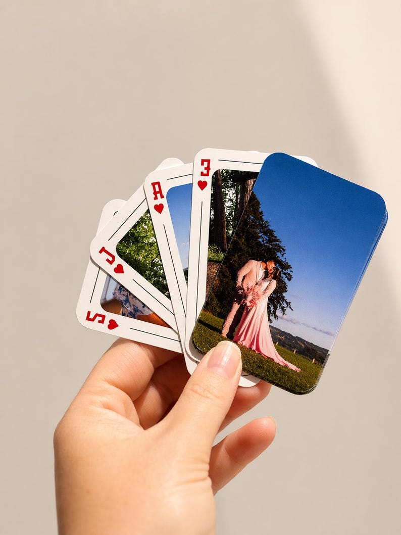 Hand holding personalised photo playing cards featuring wedding photos on custom playing card faces.