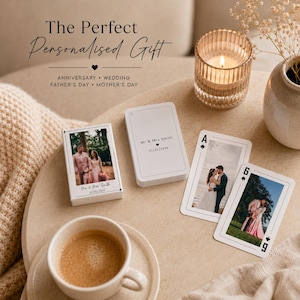 May include: A deck of custom playing cards featuring photographs of a couple on the box and individual cards. The box and cards are printed with the text Mr & Mrs Smith and 01/01/2024. The cards are displayed alongside a candle and a coffee cup.