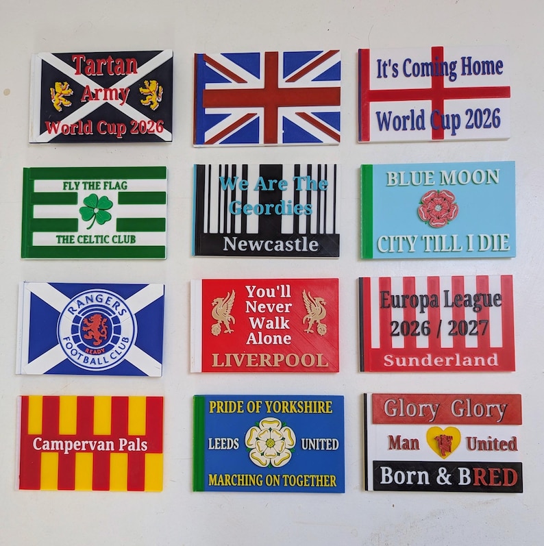 May include: A collection of twelve rectangular plastic signs featuring various sports-themed designs, including flags, team logos, and text such as Tartan Army World Cup 2026, It's Coming Home, We Are The Geordies, Blue Moon, and Glory Glory Man United.