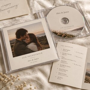 May include: A clear plastic CD jewel case containing a disc and a tracklist insert. The cover features a photograph of a couple with the text Our Soundtrack, Alex & Jamie, and 06.14.2021. The disc shows the same text and a landscape image.