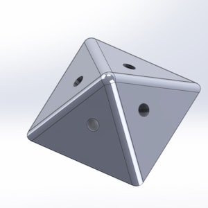 Può includere: Una forma geometrica grigia tridimensionale con cinque lati e cinque fori. La forma è simile a una piramide con una base piatta.