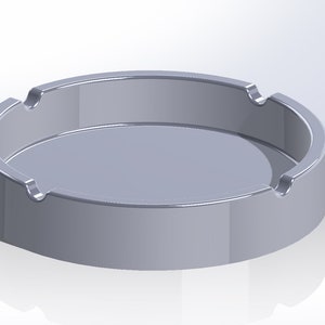 May include: A silver round ashtray with three indentations on the rim.