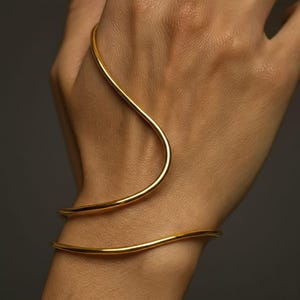Pulsera minimalista dorada, brazalete ajustable abierto, pulsera moderna con diseño ondulado, joyería escultórica llamativa, ideal para combinar con otras pulseras, regalo para ella