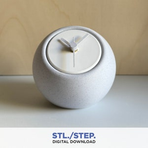 Può includere: Un orologio in ceramica bianca con un quadrante rotondo e una texture punteggiata. Le lancette dell'orologio sono argentate e il quadrante dell'orologio è bianco.
