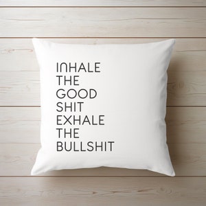 May include: White square pillow with the text "INHALE THE GOOD SHIT EXHALE THE BULLSHIT" in black, sans-serif font. The pillow is on a light wood surface.