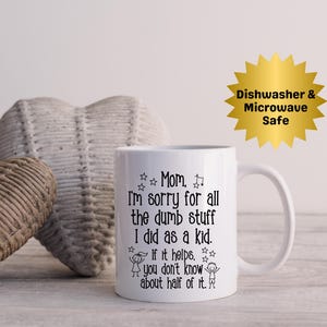 May include: White ceramic mug with a black text that reads "Mom, I'm sorry for all the dumb stuff I did as a kid. If it helps, you don't know about half of it." A gold starburst sticker says "Dishwasher & Microwave Safe."